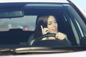 A woman driving while talking on the phone