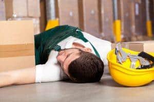 warehouse employee lying on the floor with hard hat