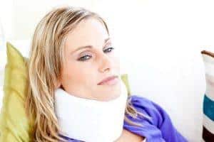 woman sitting on a sofa with a neck brace