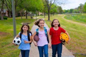 Children walking to school with sport balls