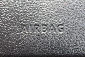 Airbag logo on textured leather car dashboard