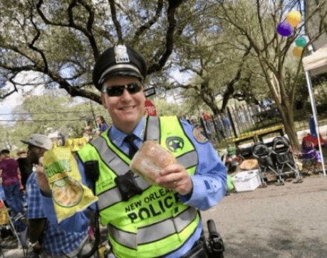A New Orleans police office enjoying his bagged lunch on the Mardi Gras parade route