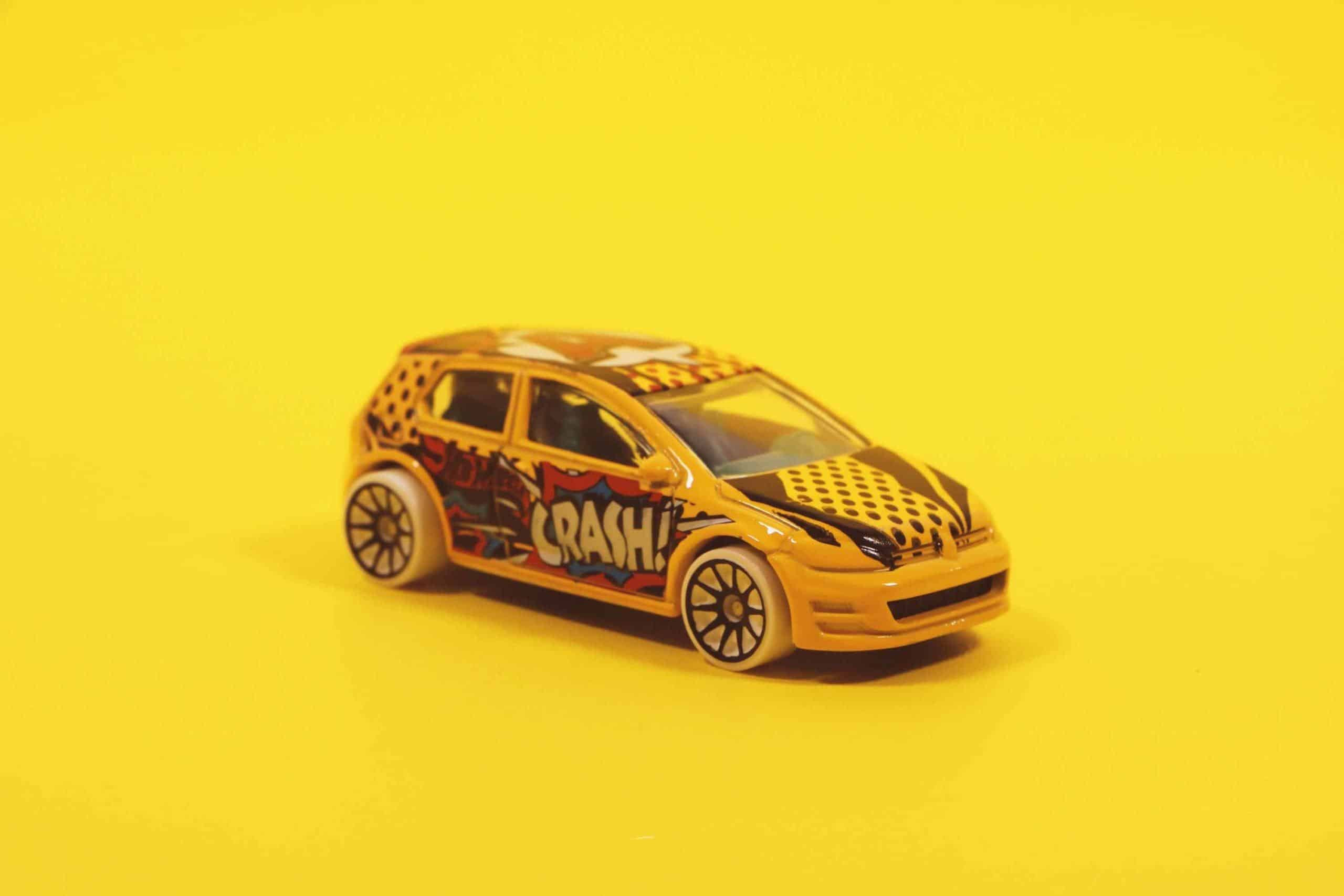 child's toy car on yellow background