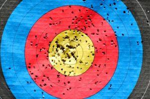 a paper shooting target with many holes from arrows