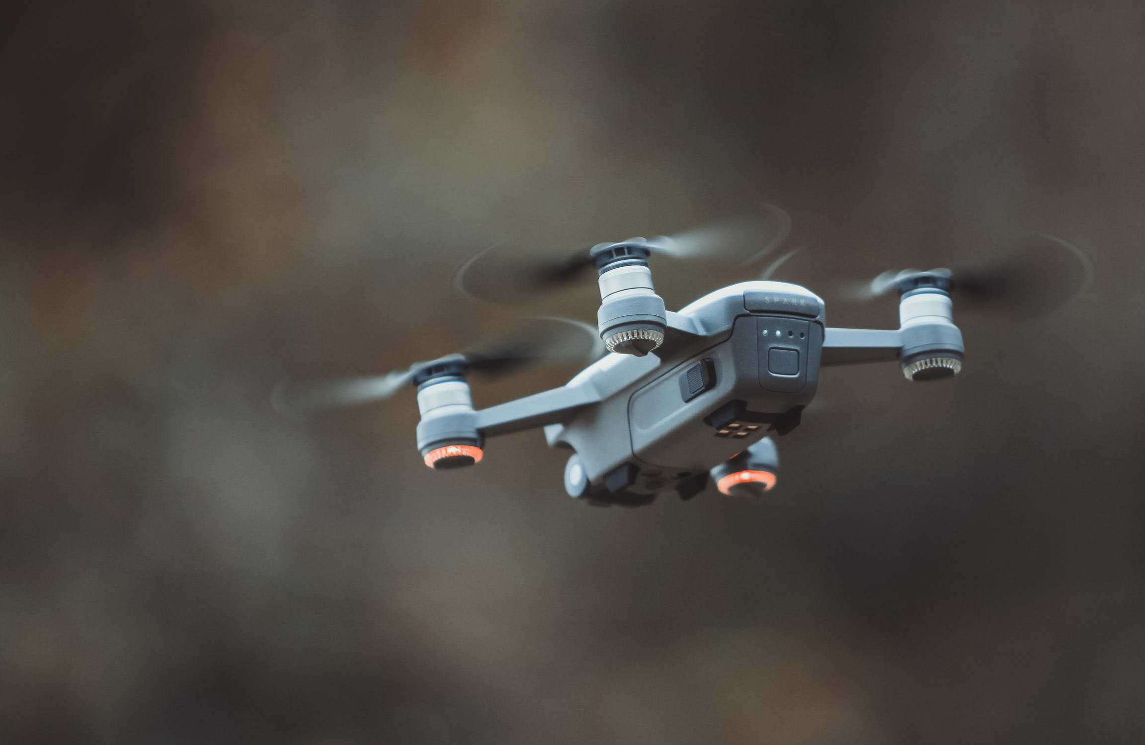 a drone hovering in front of a blurred vista