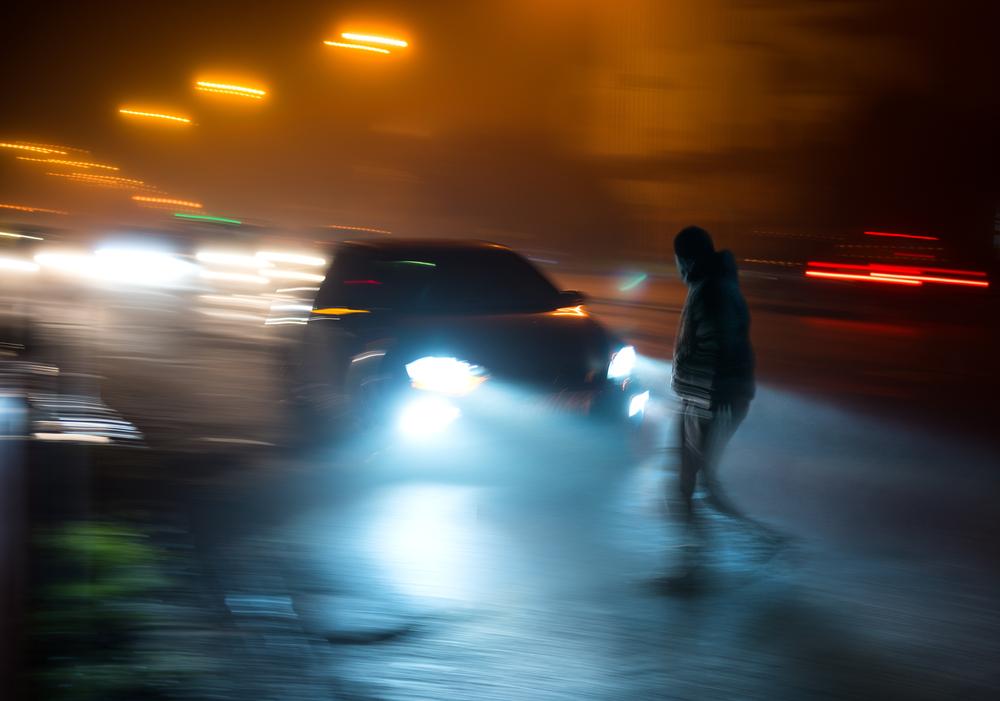 man about to get hit by a car at night