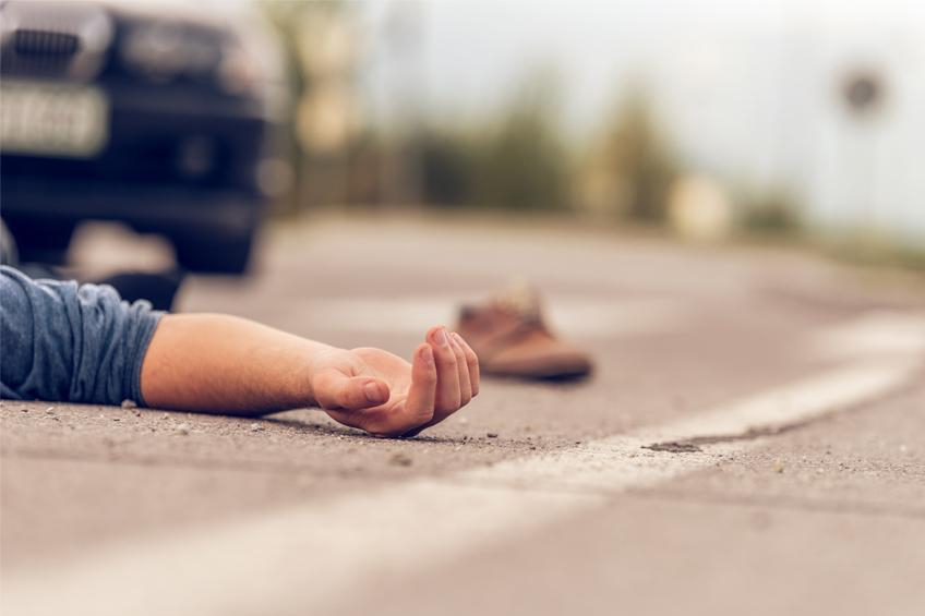 person laying on street after accident
