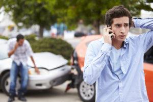 teen driver making a phone call after accident