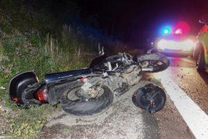 wrecked motorcycle on the side of the road at night