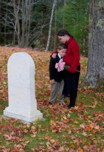 young people grieving at a headstone