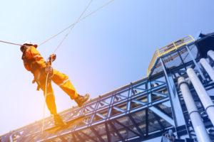 Construction worker wearing a safety harness during climb