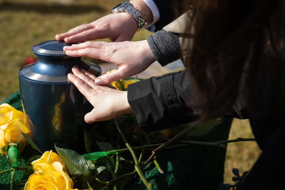 family members touch burial urn