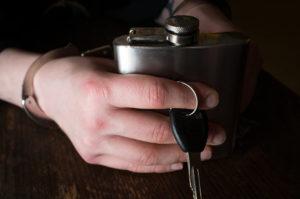 hand-holding-a-car-key-and-a-flask