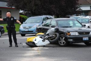 police officer directs traffic around motorcycle accident
