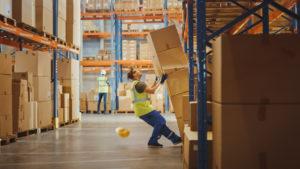 stack of cardboard boxes falls on as warehouse worker