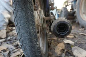 close-up of motorcycle wheel and exhaust pipe
