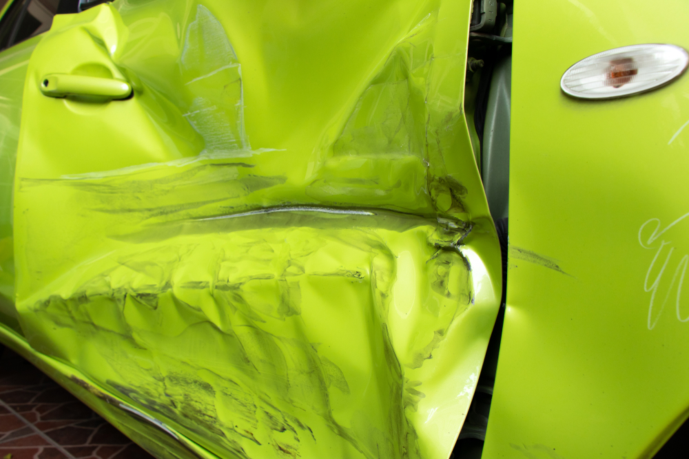 crunched-up side of a green car
