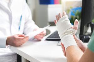 Man with injured wrist reviews treatment plan with doctor