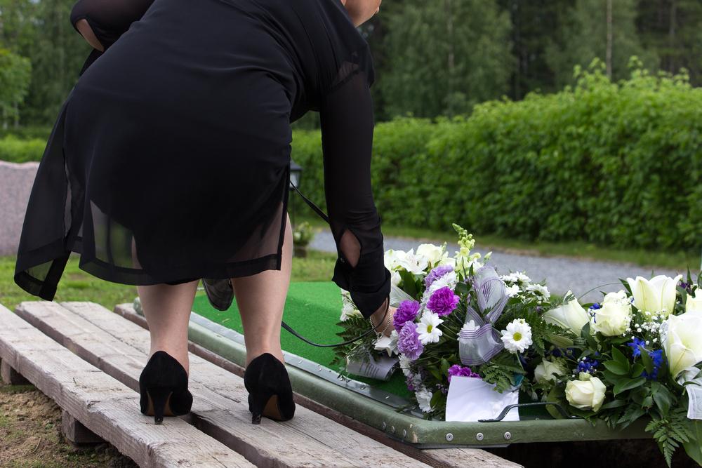 woman laying flowers on a grave