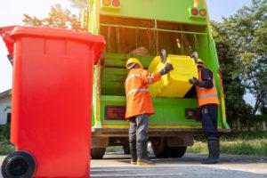 sanitation workers load garbage truck