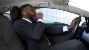 exhausted driver yawns behind the wheel