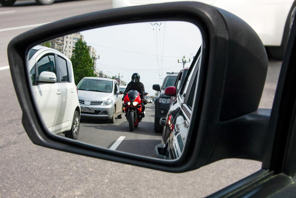 motorcycle rider lane splitting in heavy traffic