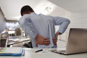man with back pain at his desk