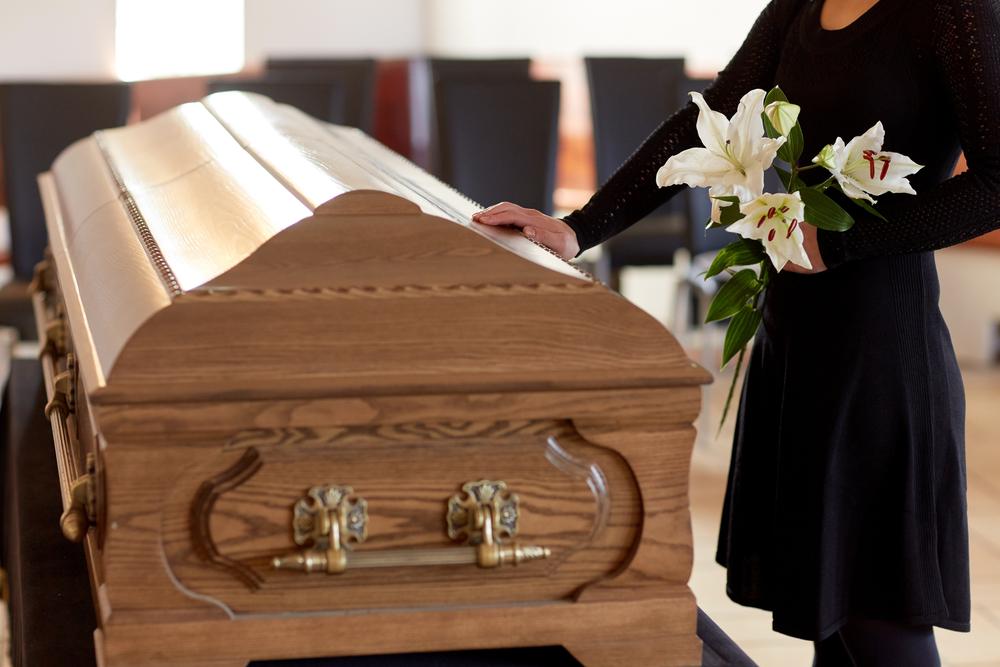 woman with her hand on a coffin