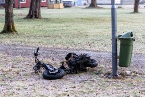 burnt abandoned moped on the ground