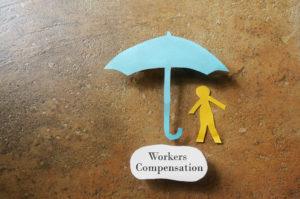 paper man under umbrella of workers’ compensation