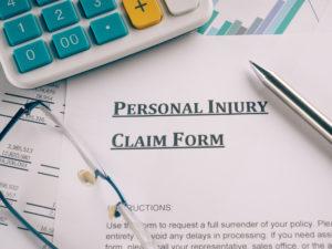 A blank personal injury claim form with bills under it.
