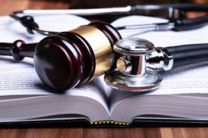 stethoscope and mallet over open law book